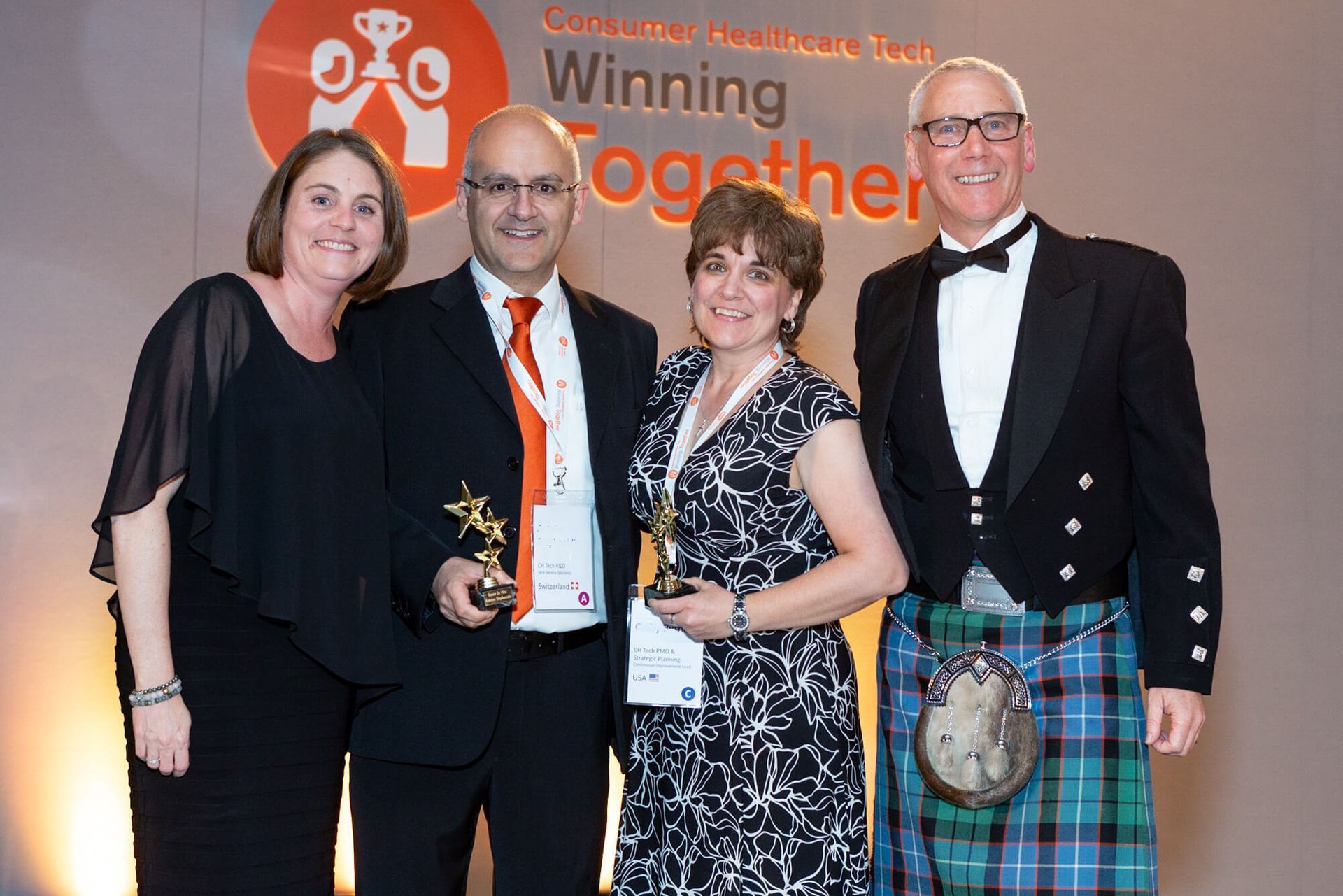 Group on stage having their photo captured at corporate awards ceremony in London