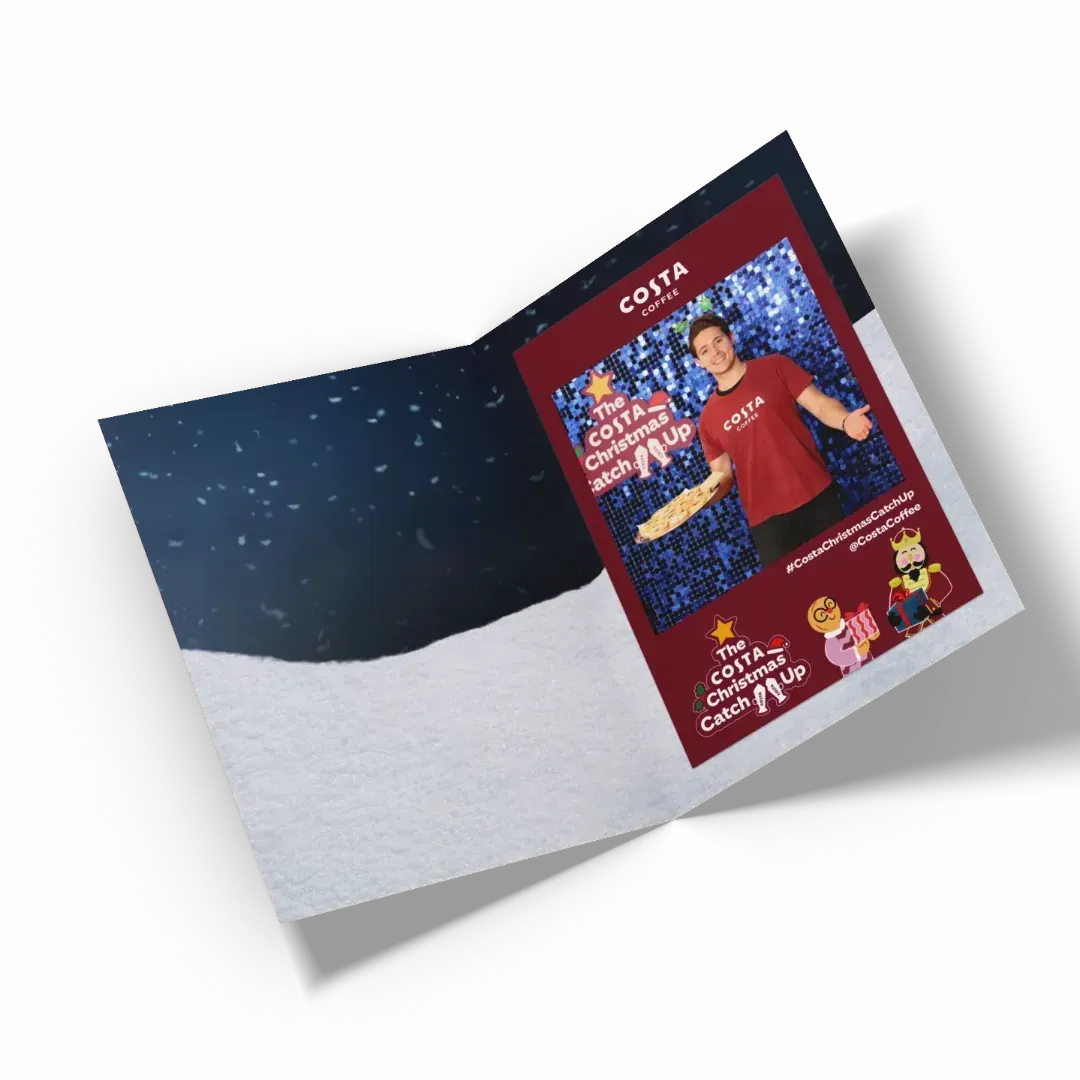 Branded Photo Wallet Costa Coffee branded photo wallet open. The interior shows a slot to hold a photo. A Christmas-themed Costa Coffee photo is inserted into the wallet. Produced by Ghelani Studios.