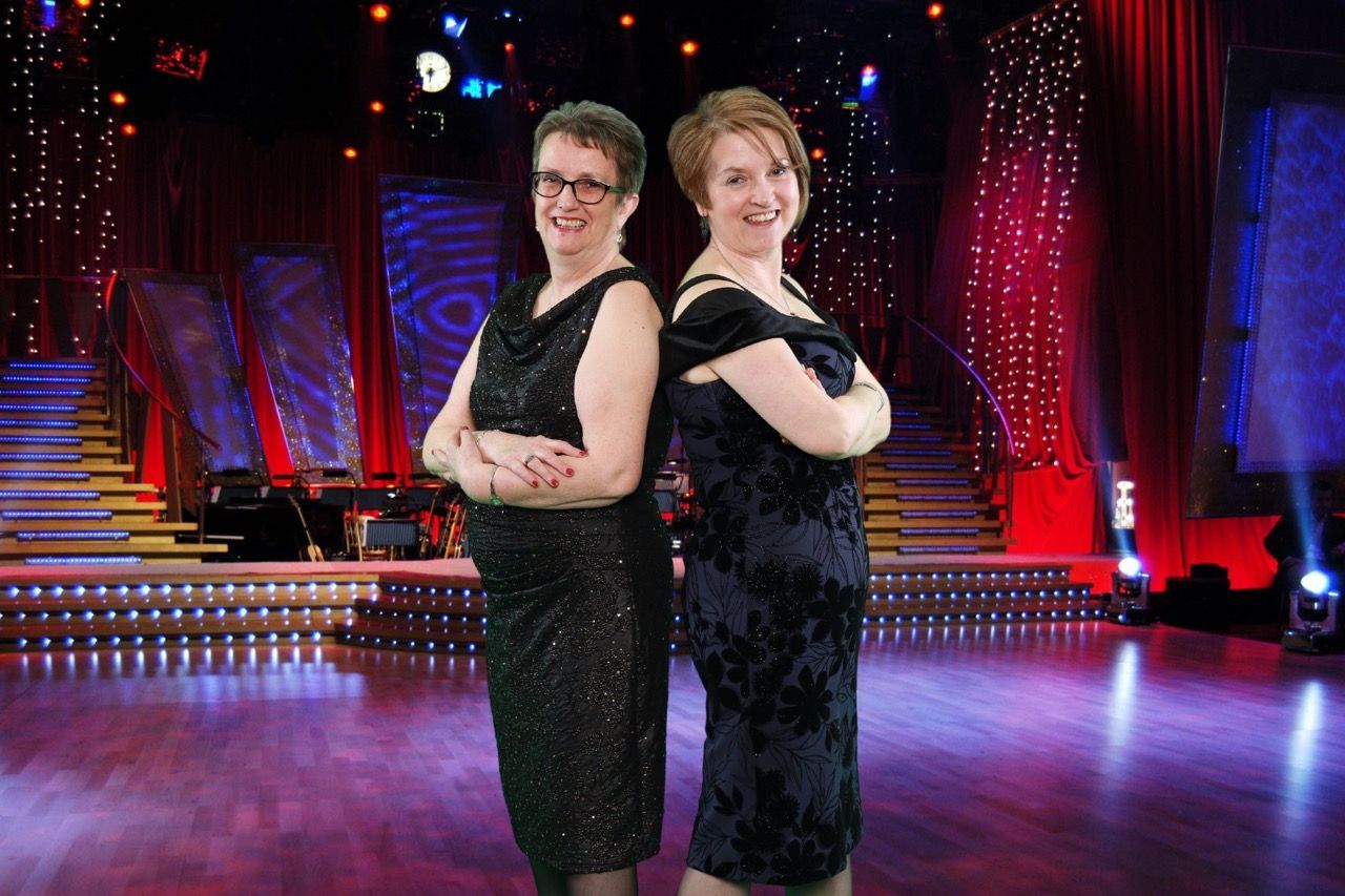 A group of people standing in front of a green screen backdrop, with various images and backgrounds superimposed on the green screen in the final photo