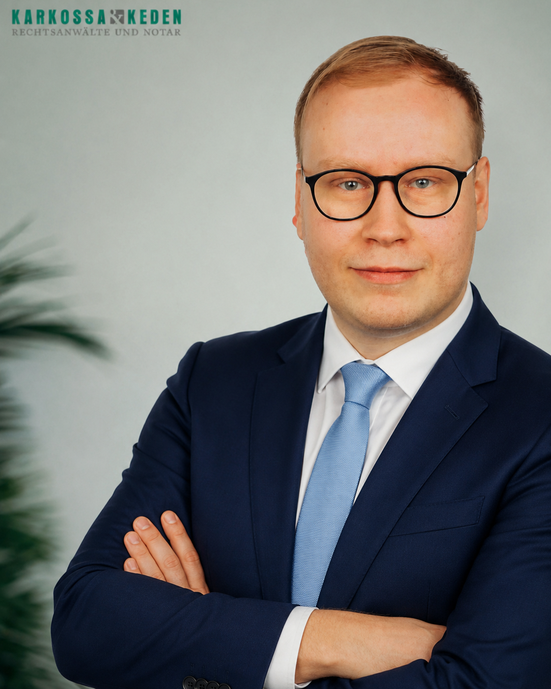 Mann mit Brille, verschränkten Armen und Button-Down-Hemd. Grüner Text oben links.