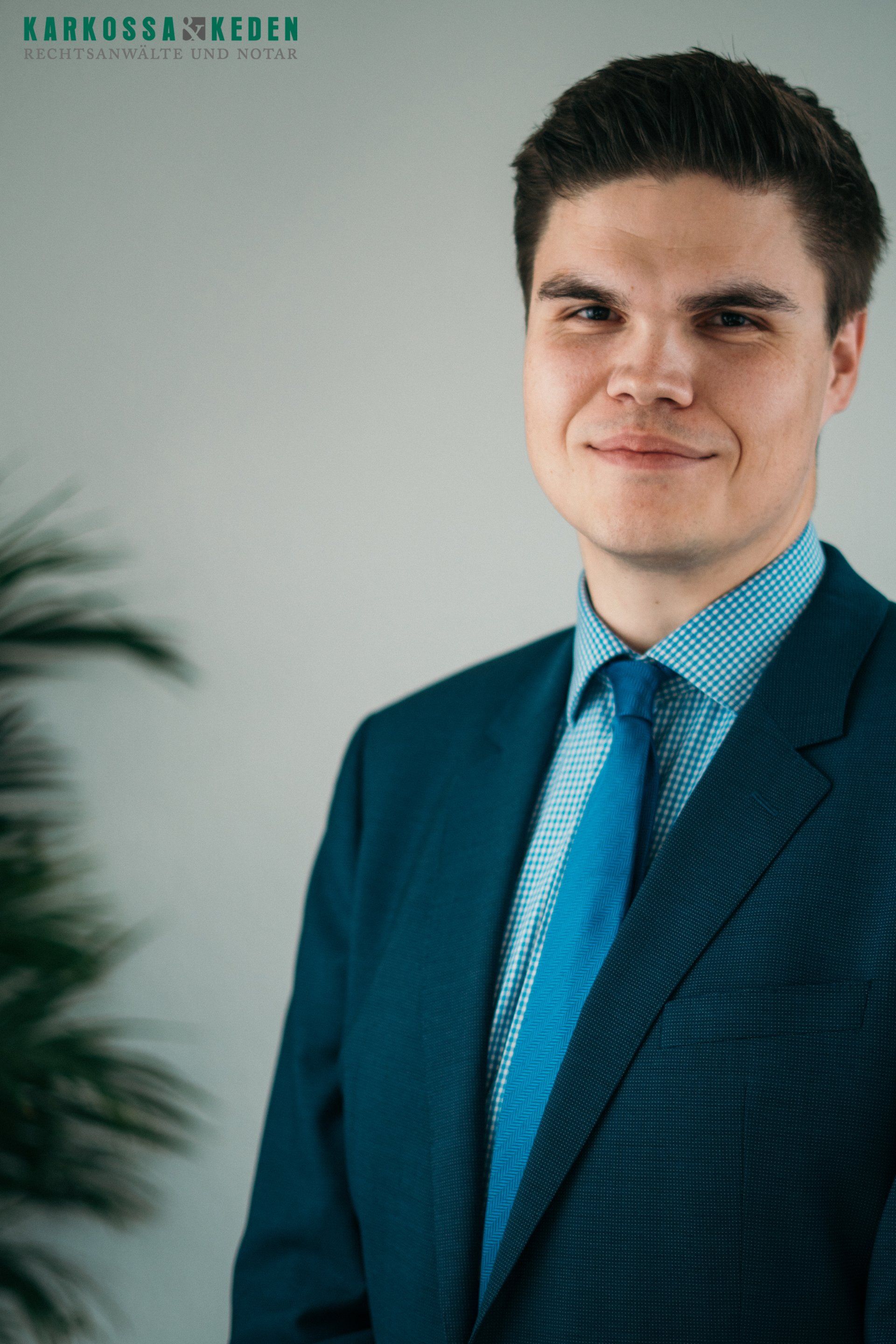 Mann im blauen Anzug lächelt in die Kamera.