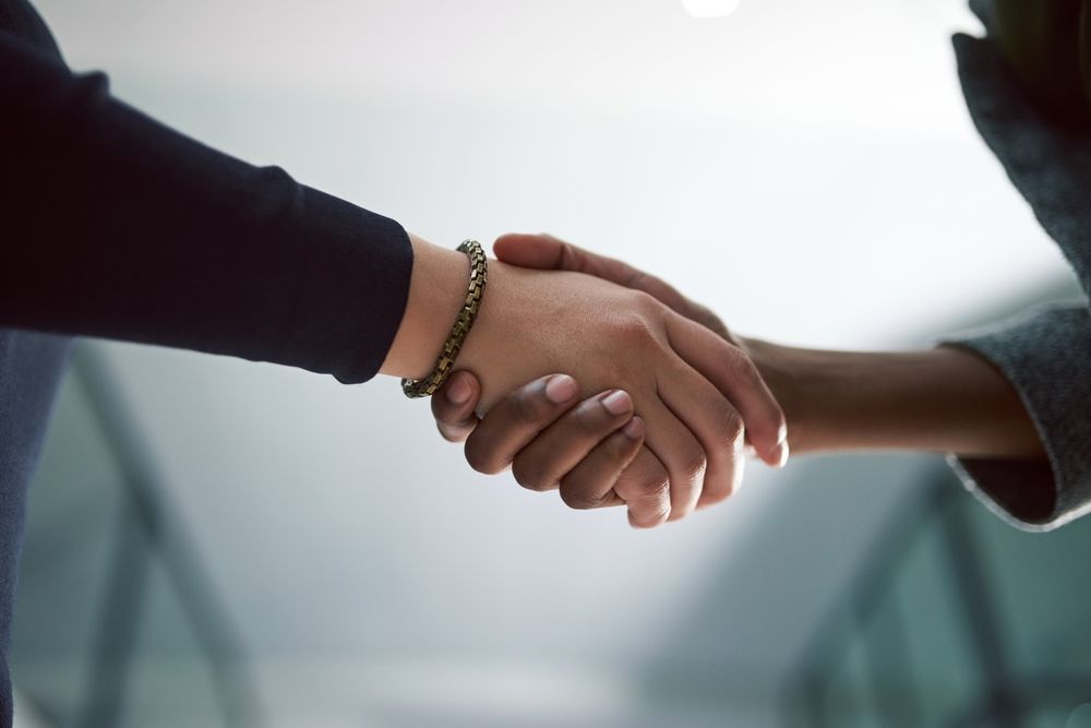 A close up of two people shaking hands.