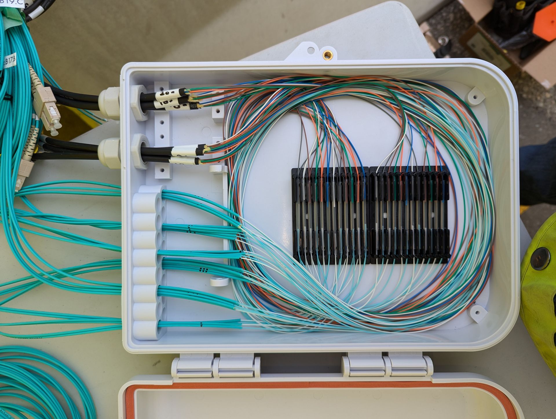Open fiber optic cable junction box with bundles of fusion splicing