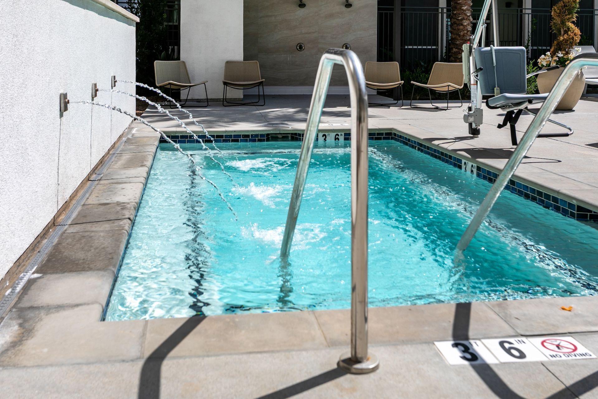 Small pool with jets and handrails. A spa-like setting.