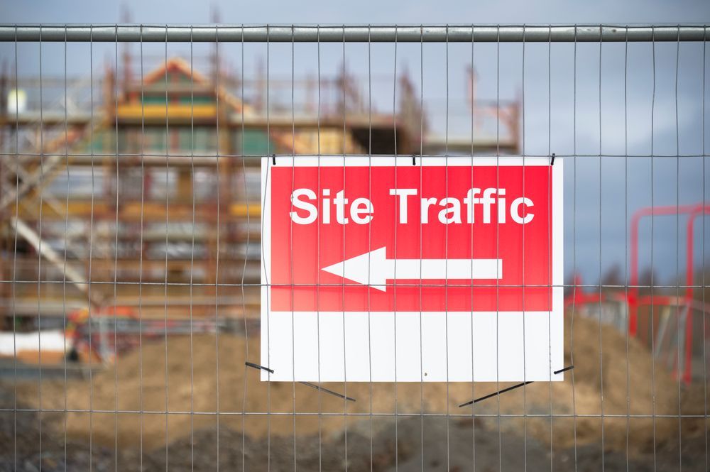 A Red And White Sign On A Fence Says Site Traffic With An Arrow Pointing To The Right — JW Signs and Designs In Cairns, QLD