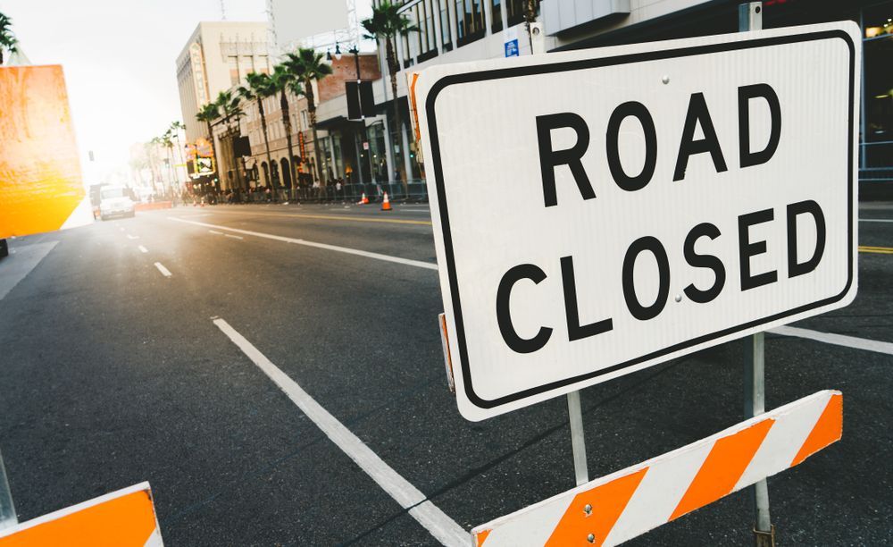 A Road Closed Sign Is Sitting On The Side Of The Road — JW Signs and Designs In Mount Isa, QLD