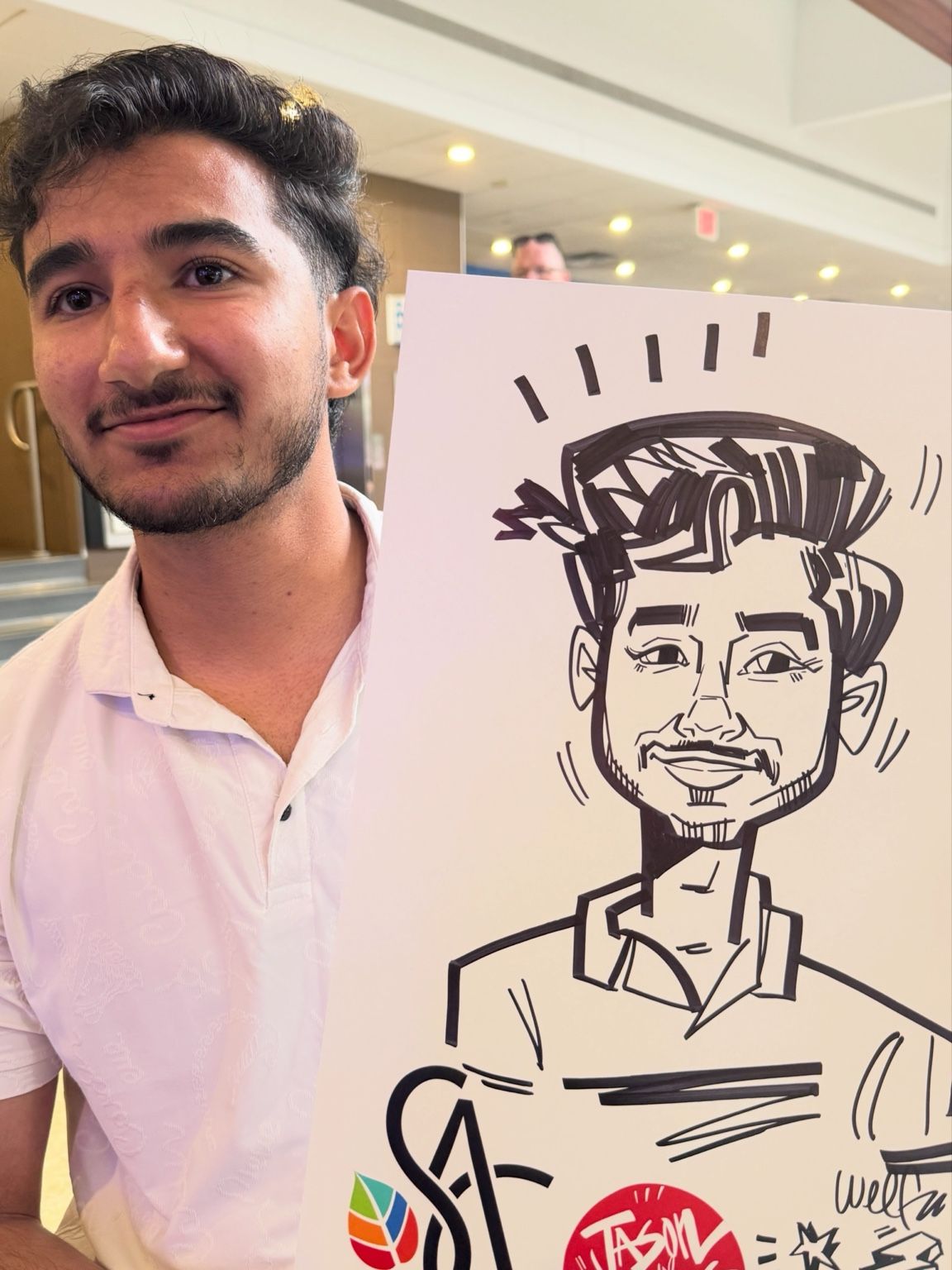 Fleming College guest in a white shirt holding his personalized live caricature by Jason Wilkins.