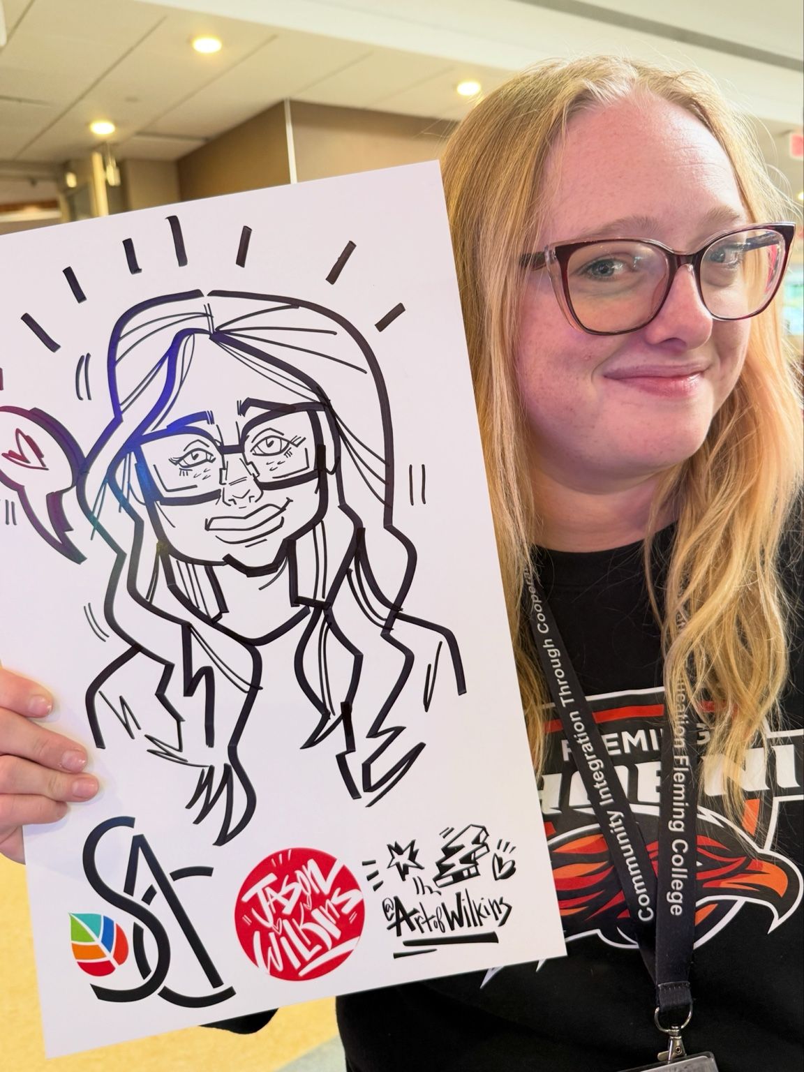 Fleming College guest holding her personalized live caricature by Jason Wilkins.
