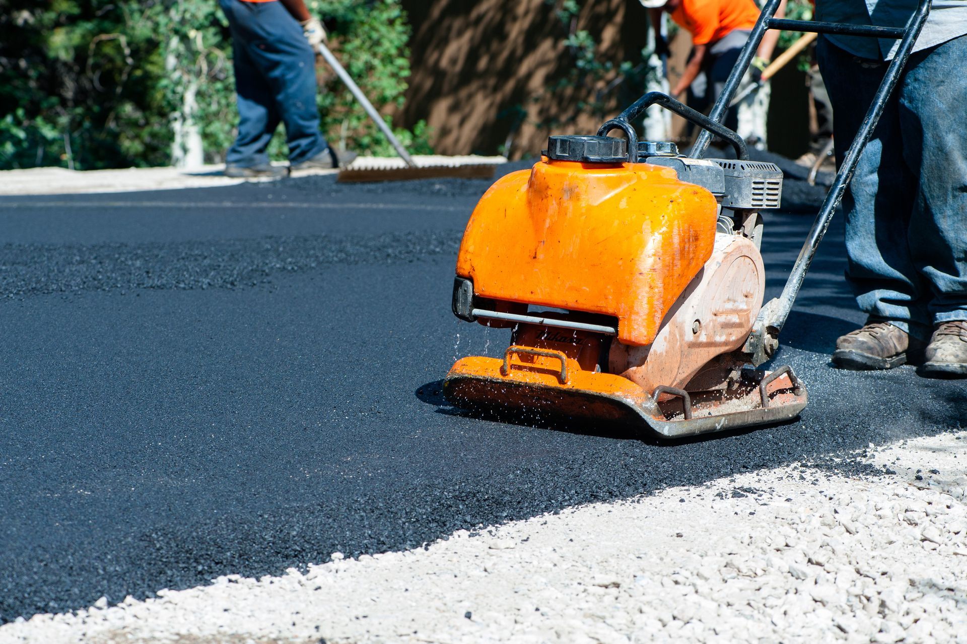 Asphalt paving services by Wells Paving & Seal Coating in Charlottesville, VA, with workers using as