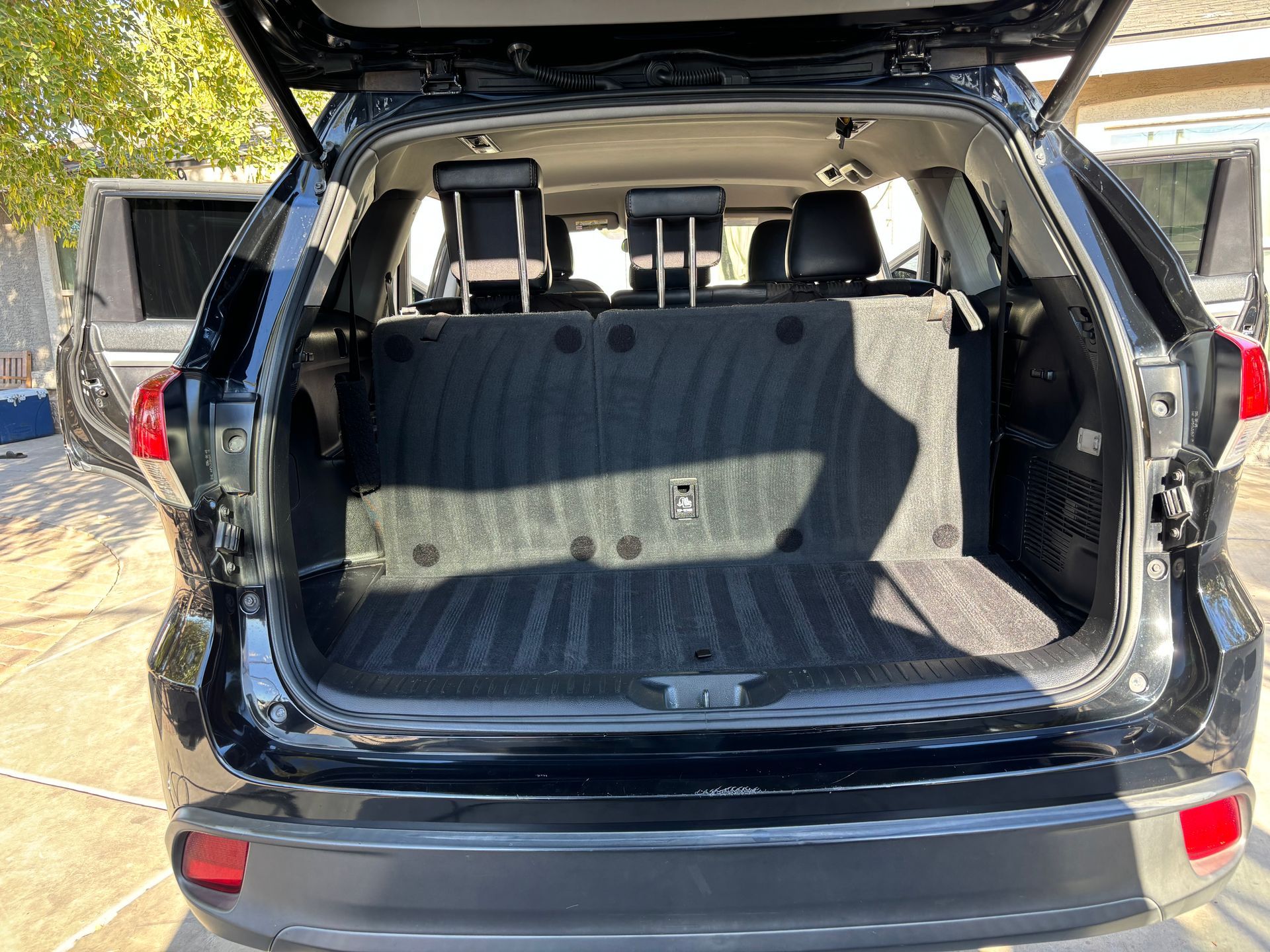 Open SUV cargo area with rear seats folded up and empty trunk space.