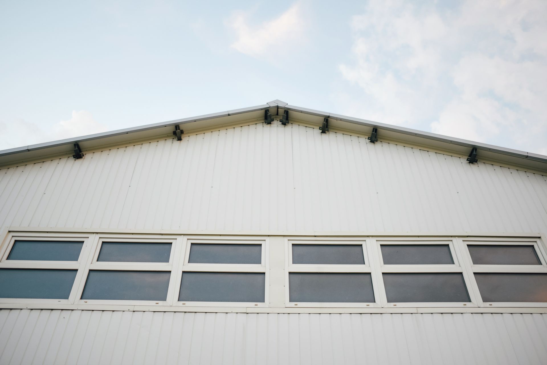 A white building with a lot of windows and a blue sky in the background A white building with a lot of windows and a blue sky in the background