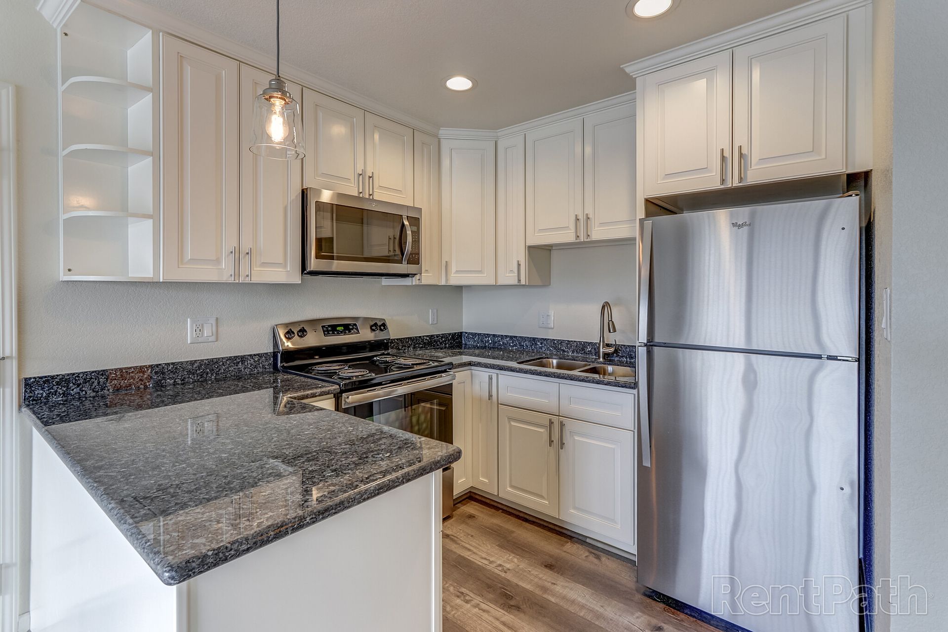 A kitchen with white cabinets and stainless steel appliances