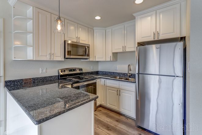 A kitchen with white cabinets and stainless steel appliances