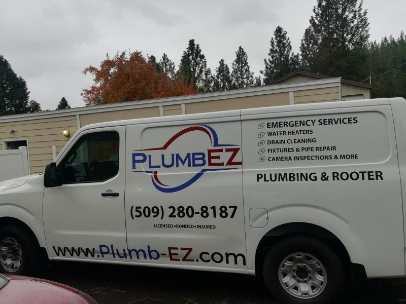 A white work van parked outdoors with the 