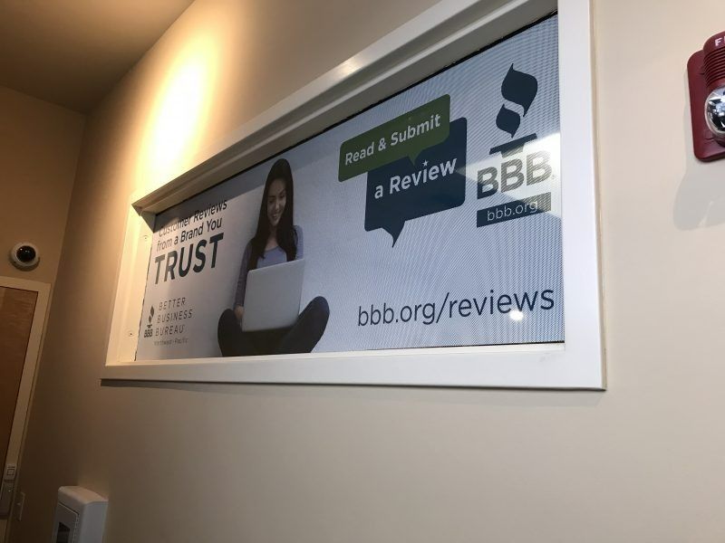 A framed BBB sign on a wall encourages customers to 