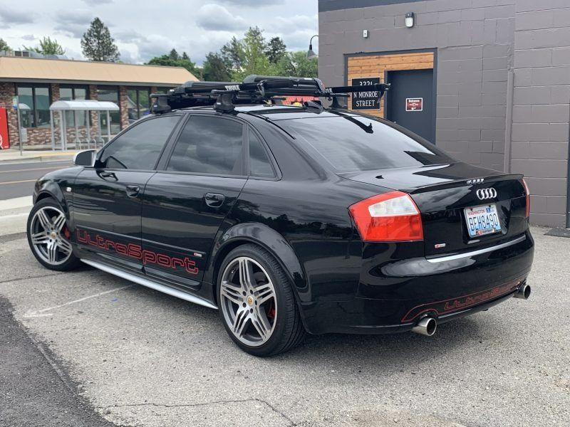 A black Audi sedan with a roof rack and red 