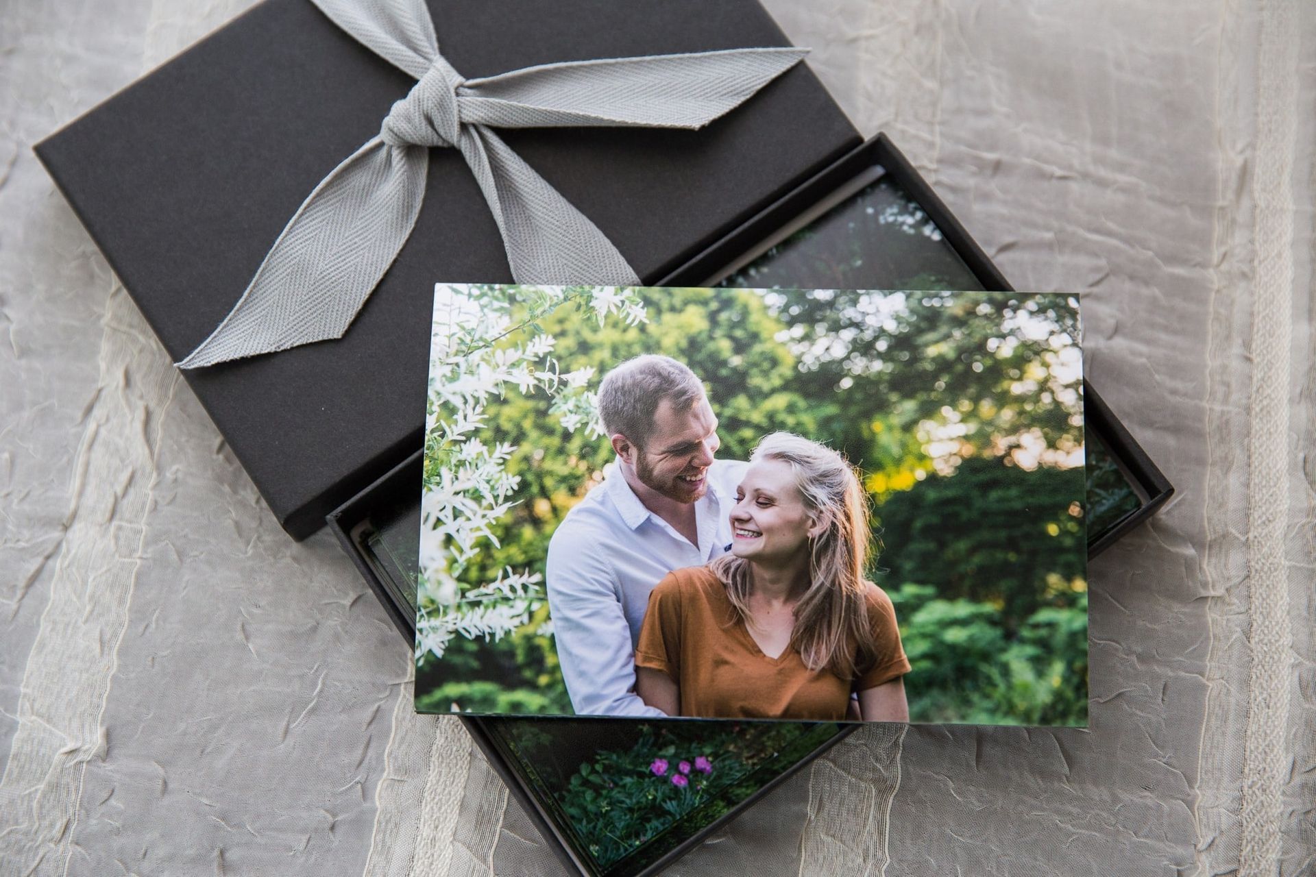 A picture of a man and woman sitting next to each other in a box with a bow.