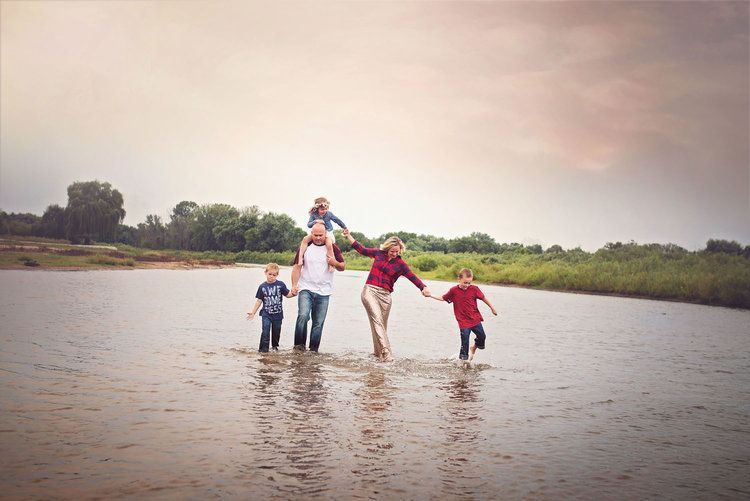 A family is walking through a muddy river.