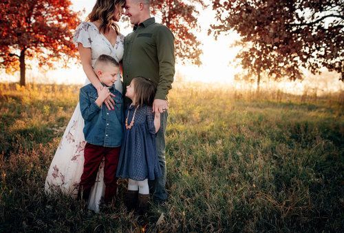 A family is posing for a picture in a field.