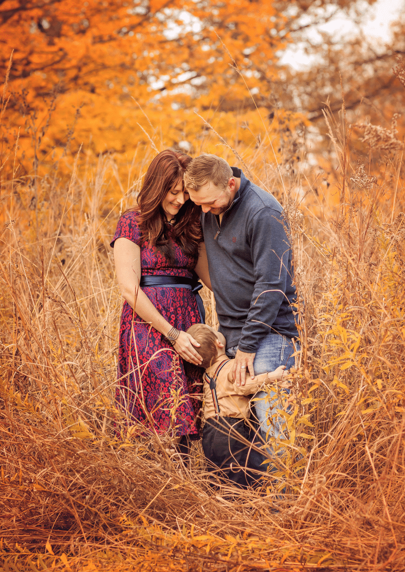 A family is posing for a picture in a field of tall grass.