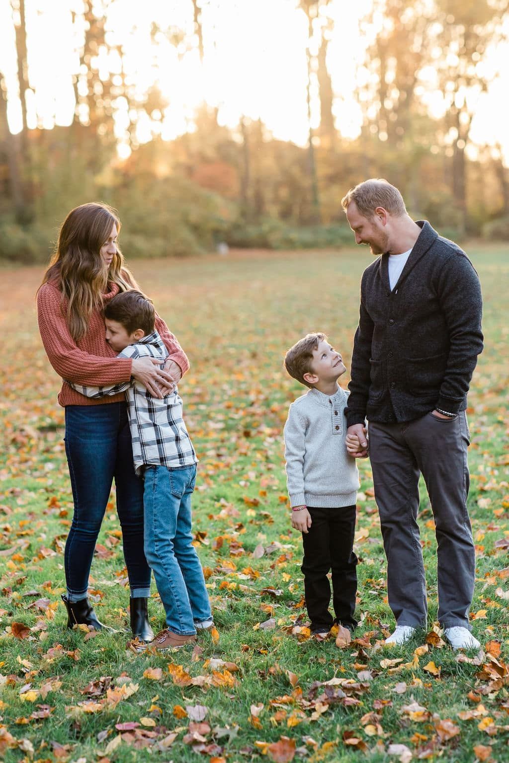 A family is standing in a field holding hands.