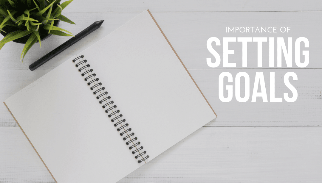 A notebook with the words setting goals written on it