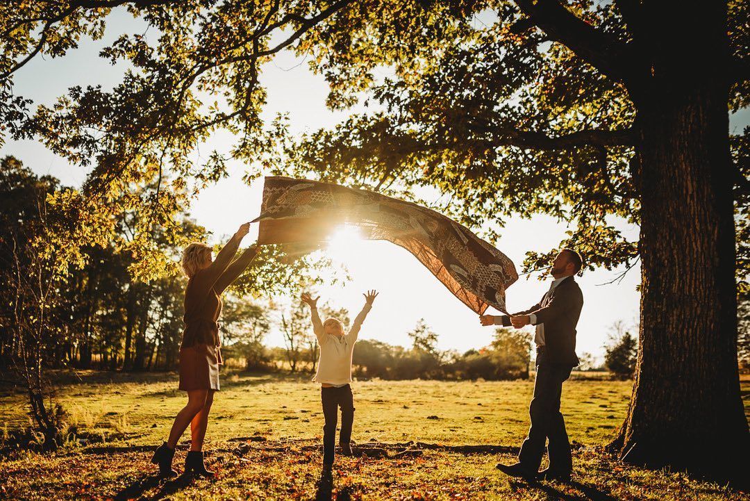 A family is playing with a scarf in a park.