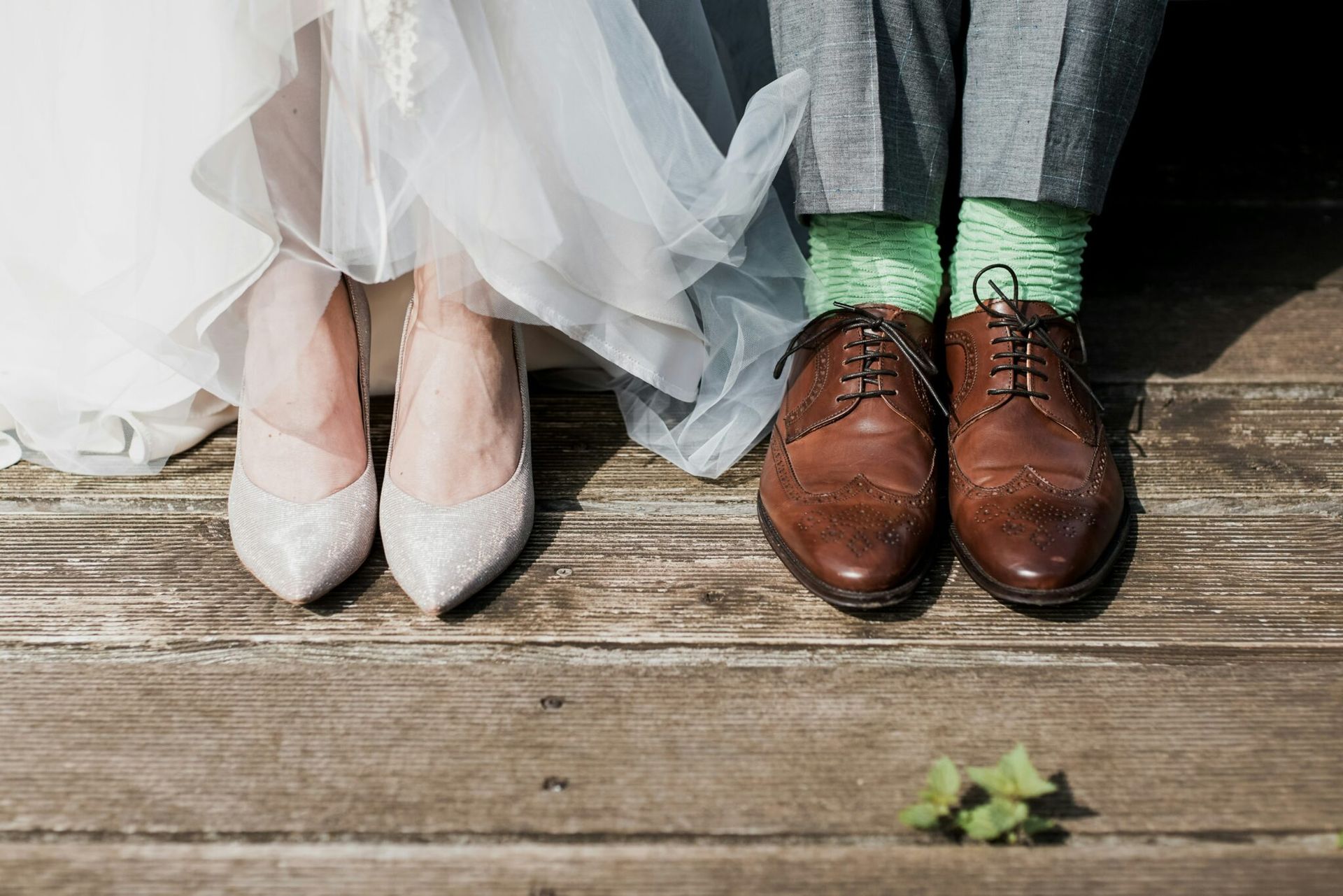 The bride and groom are wearing green socks and brown shoes.