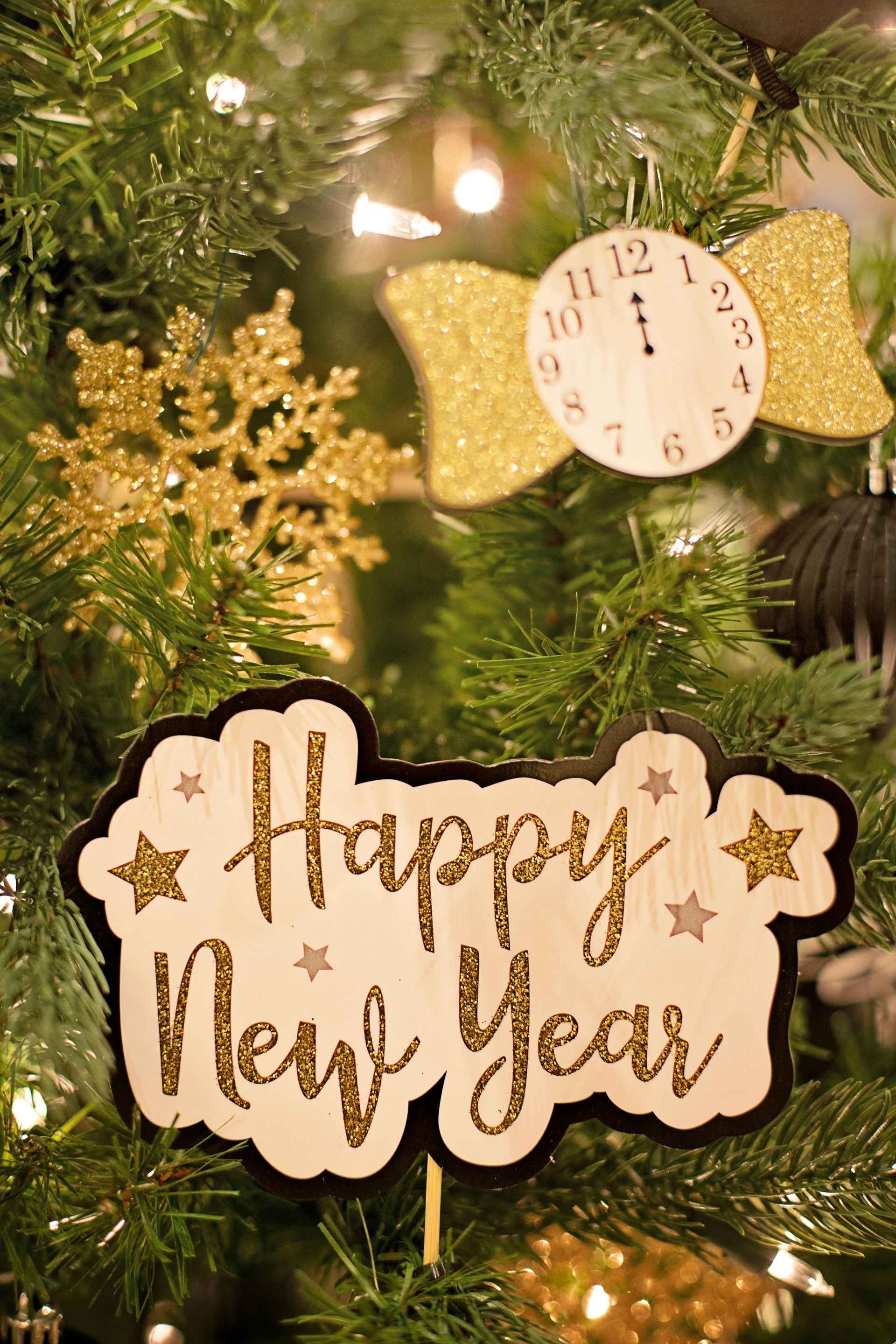 A christmas tree with a happy new year sign hanging from it.