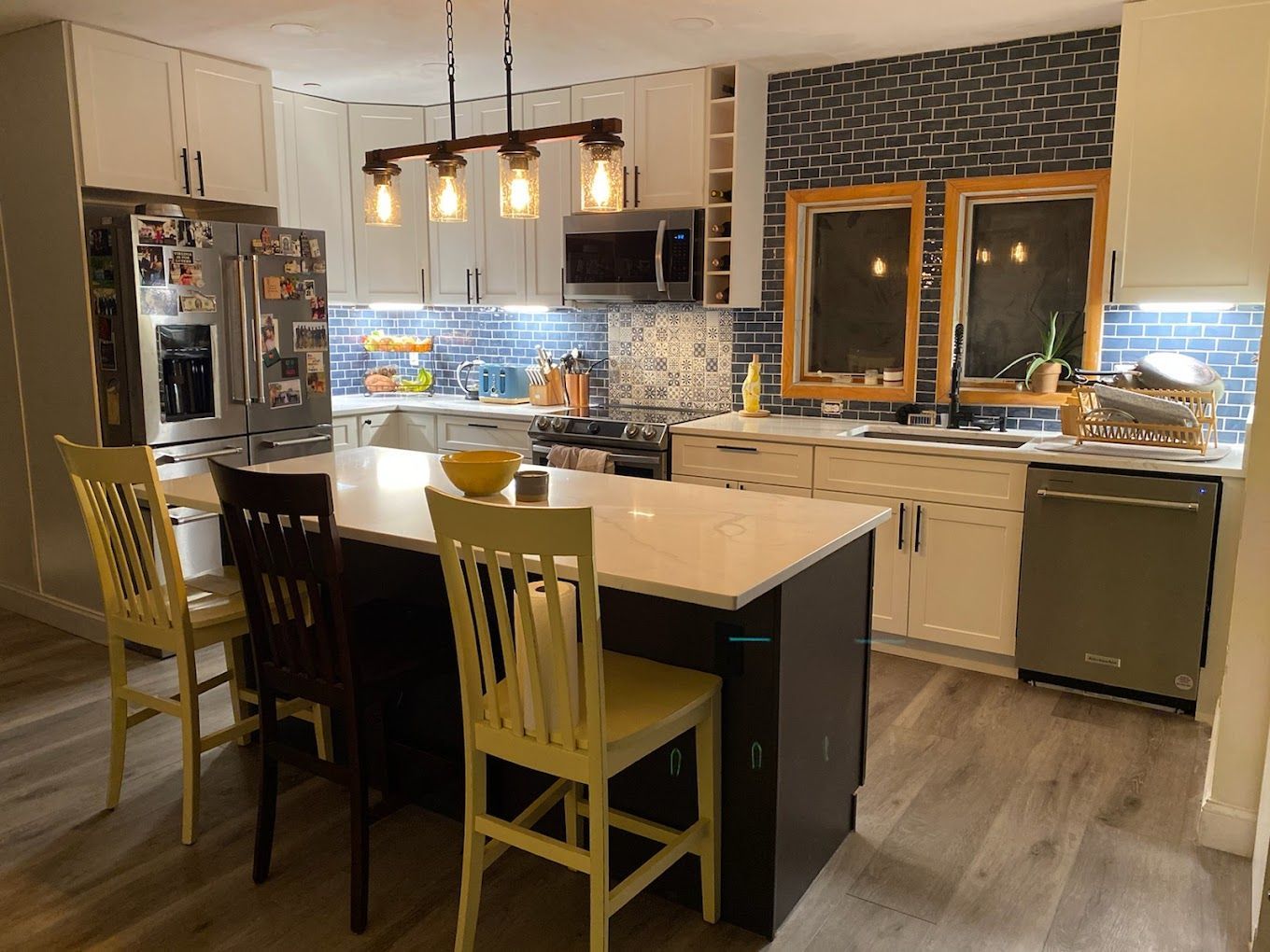 A kitchen with a large island and chairs in it.