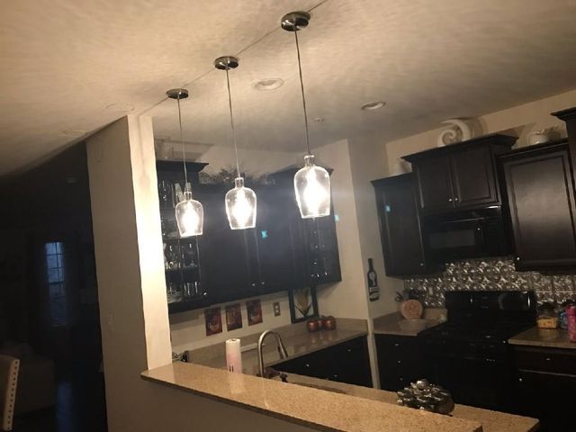 A kitchen with three pendant lights hanging from the ceiling