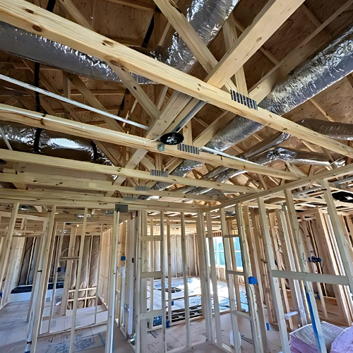 The inside of a house under construction with a lot of wooden beams.
