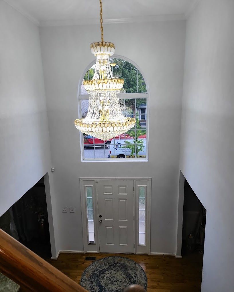 A large chandelier is hanging from the ceiling in a hallway