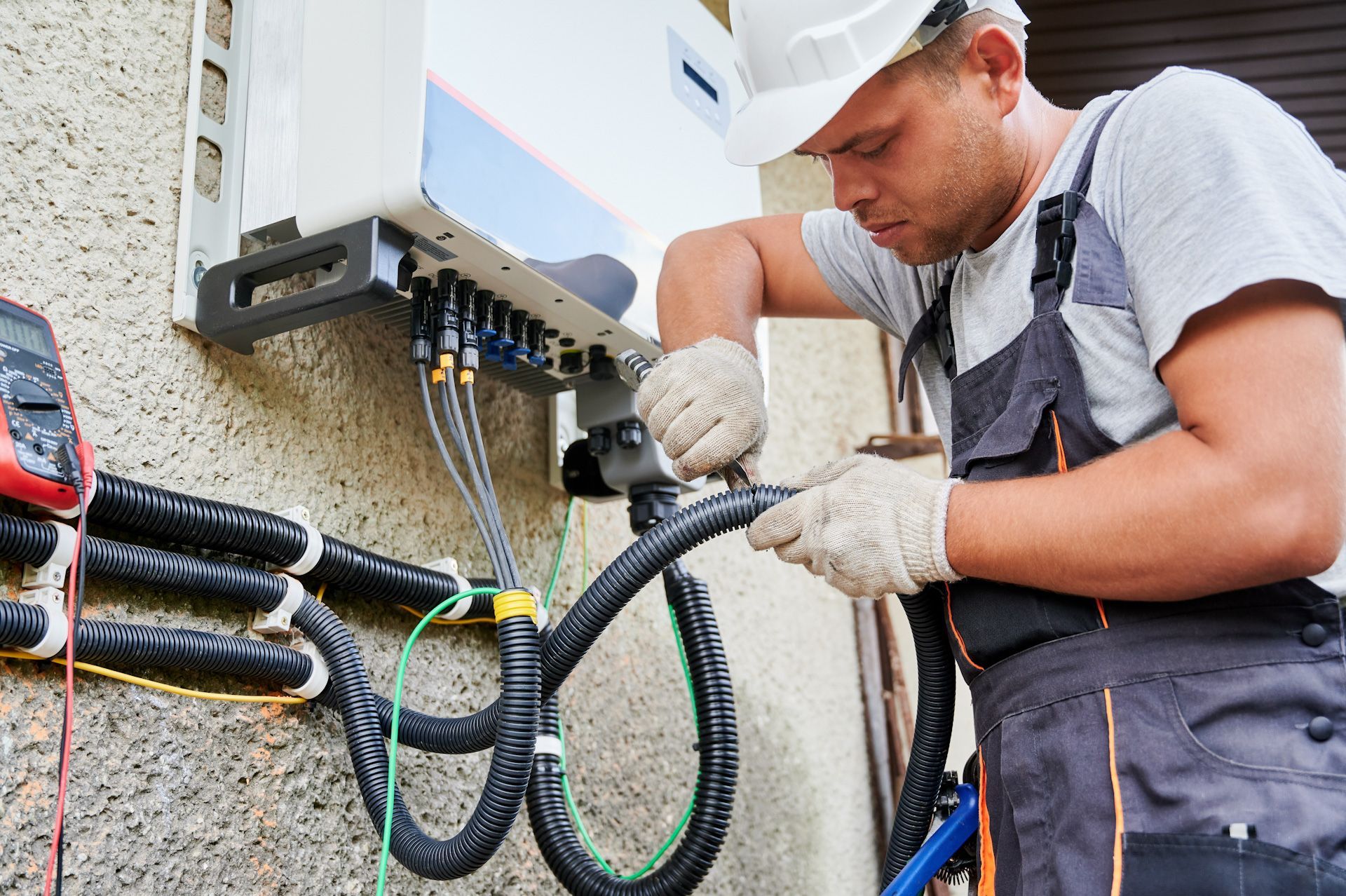 A man in a hard hat is working on a solar panel.