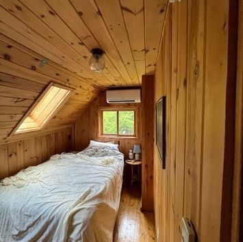 A small bedroom with a bed and a window