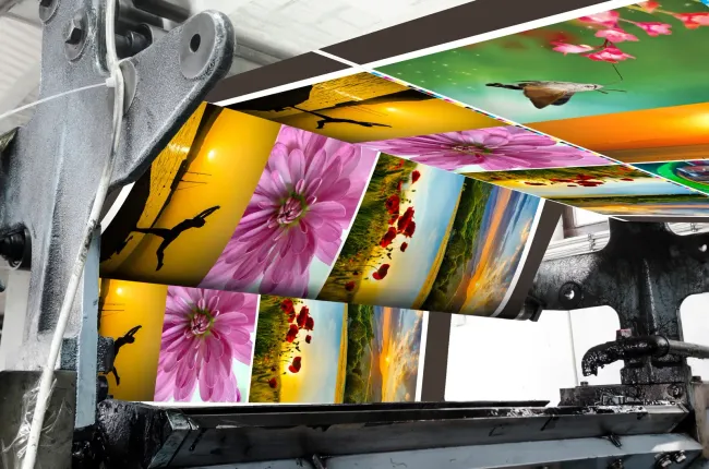 Printing press with colorful images rolling through.