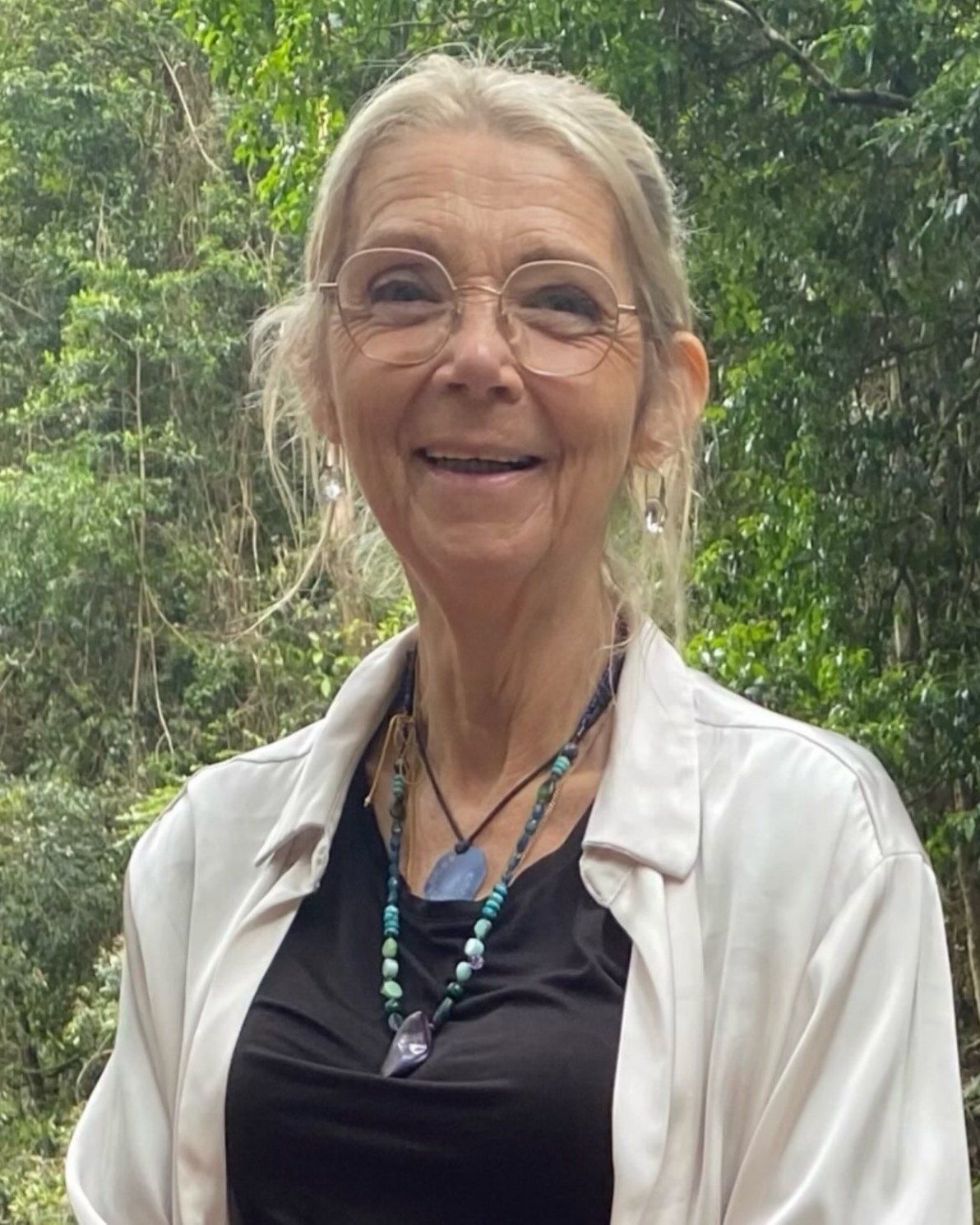 Sandie, life transition coach, smiling in the rainforest