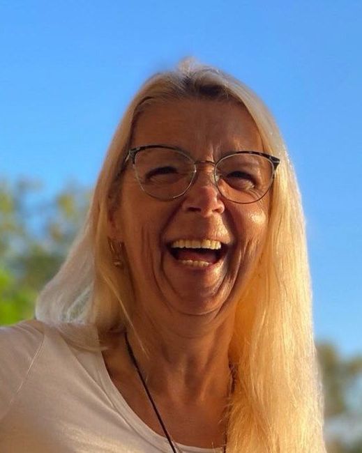 Sandie, life transition coach, laughing outdoors on a sunny day