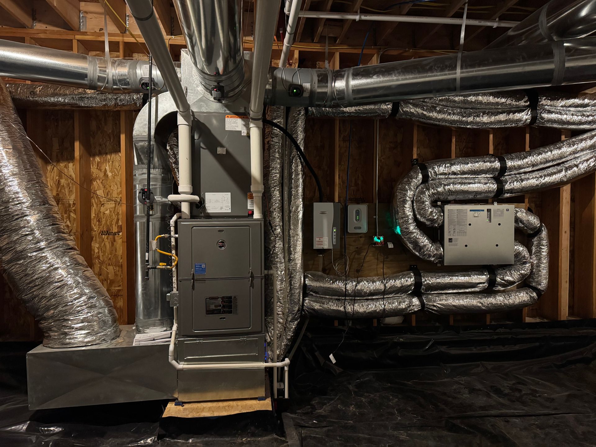 Basement HVAC equipment with ductwork, metal vents, and exposed insulation against unfinished walls