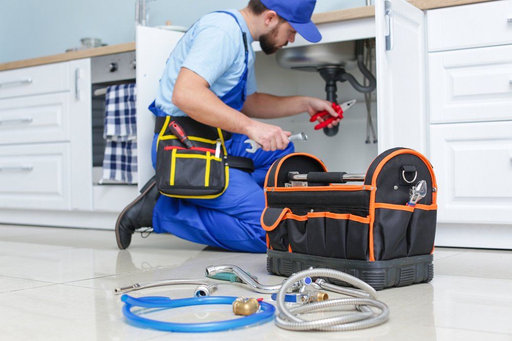 Plumber Repairing The Pipe Under The Sink