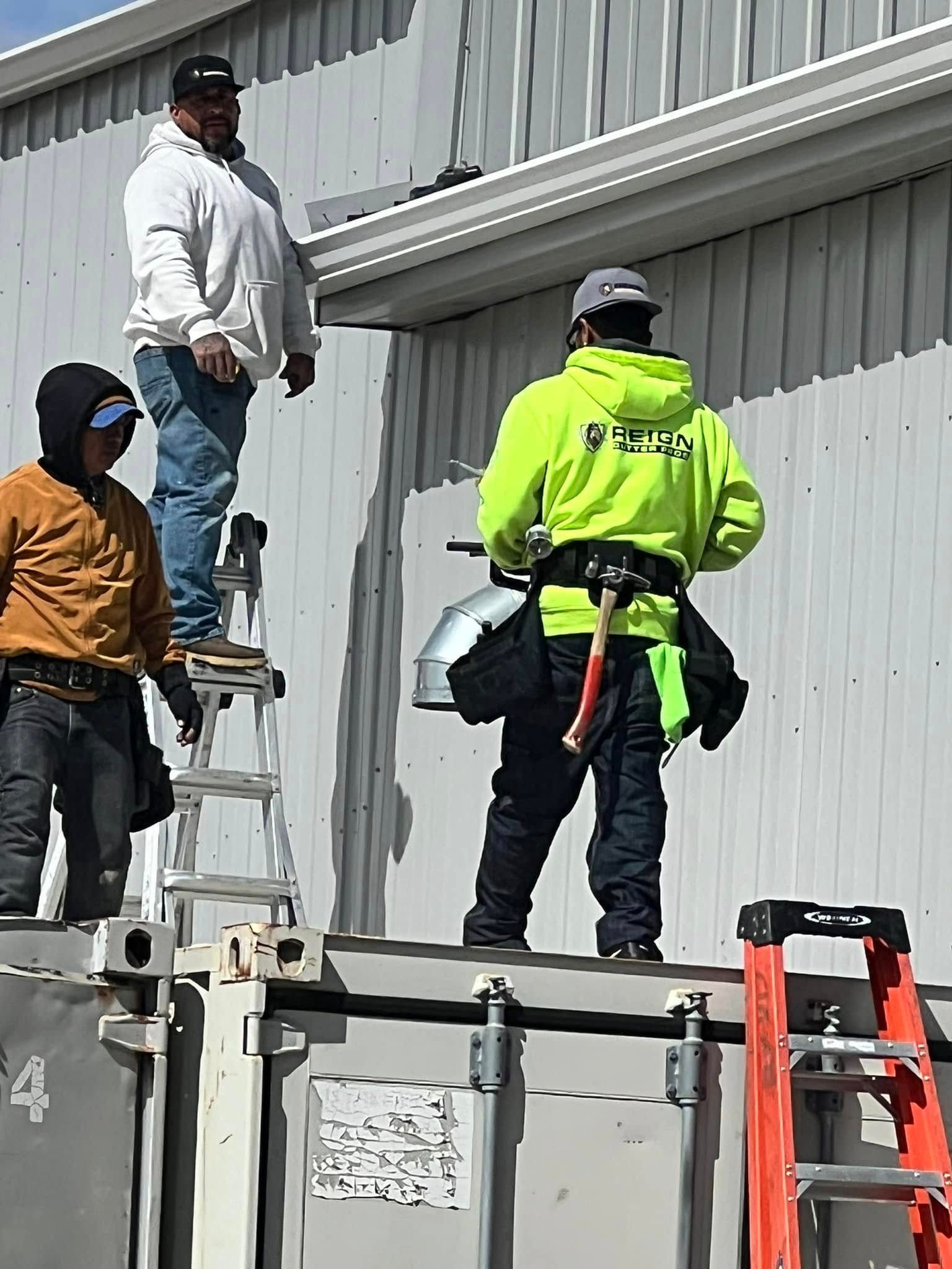 A group of construction workers are working on the side of a building.