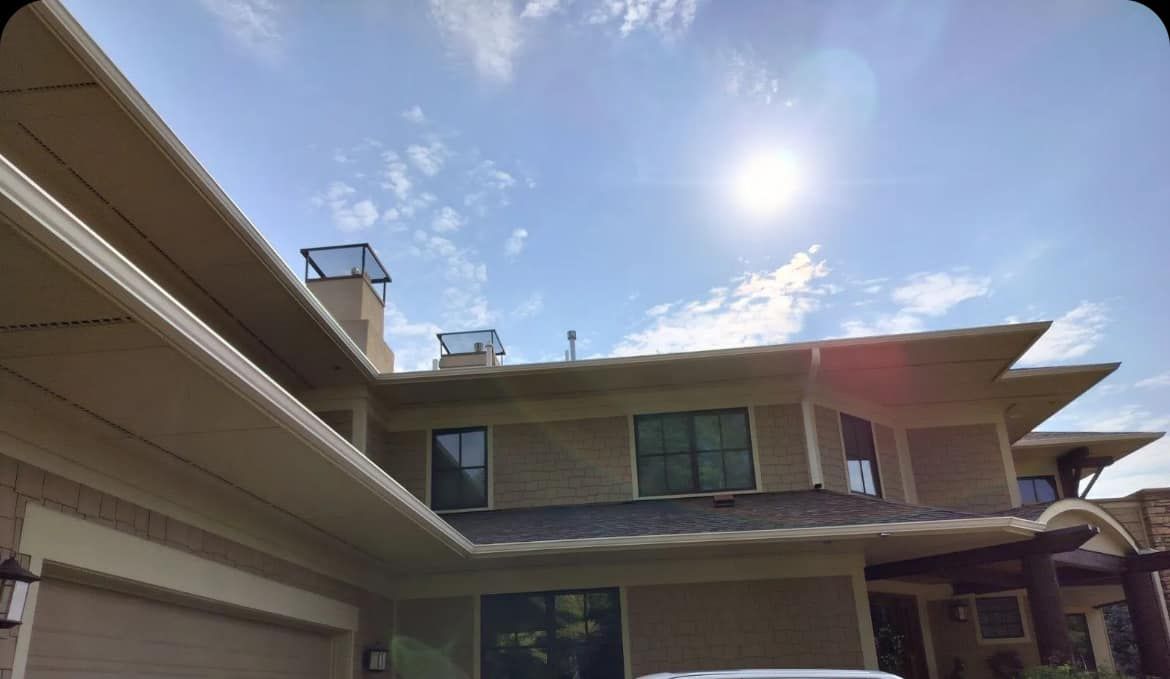 A large house with a car parked in front of it on a sunny day.