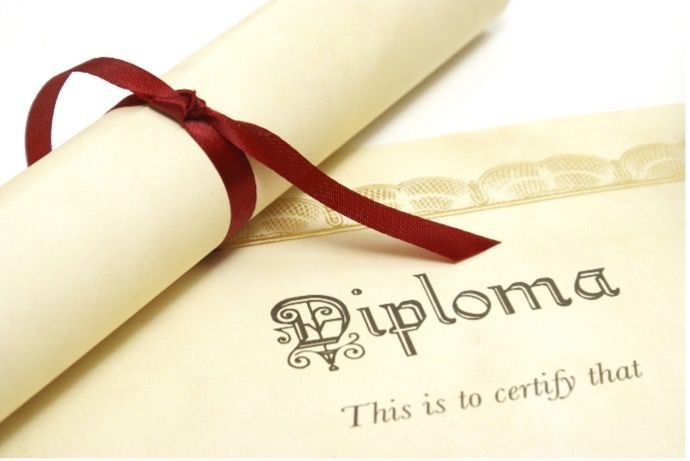 Rolled diploma tied with a red ribbon on a certificate