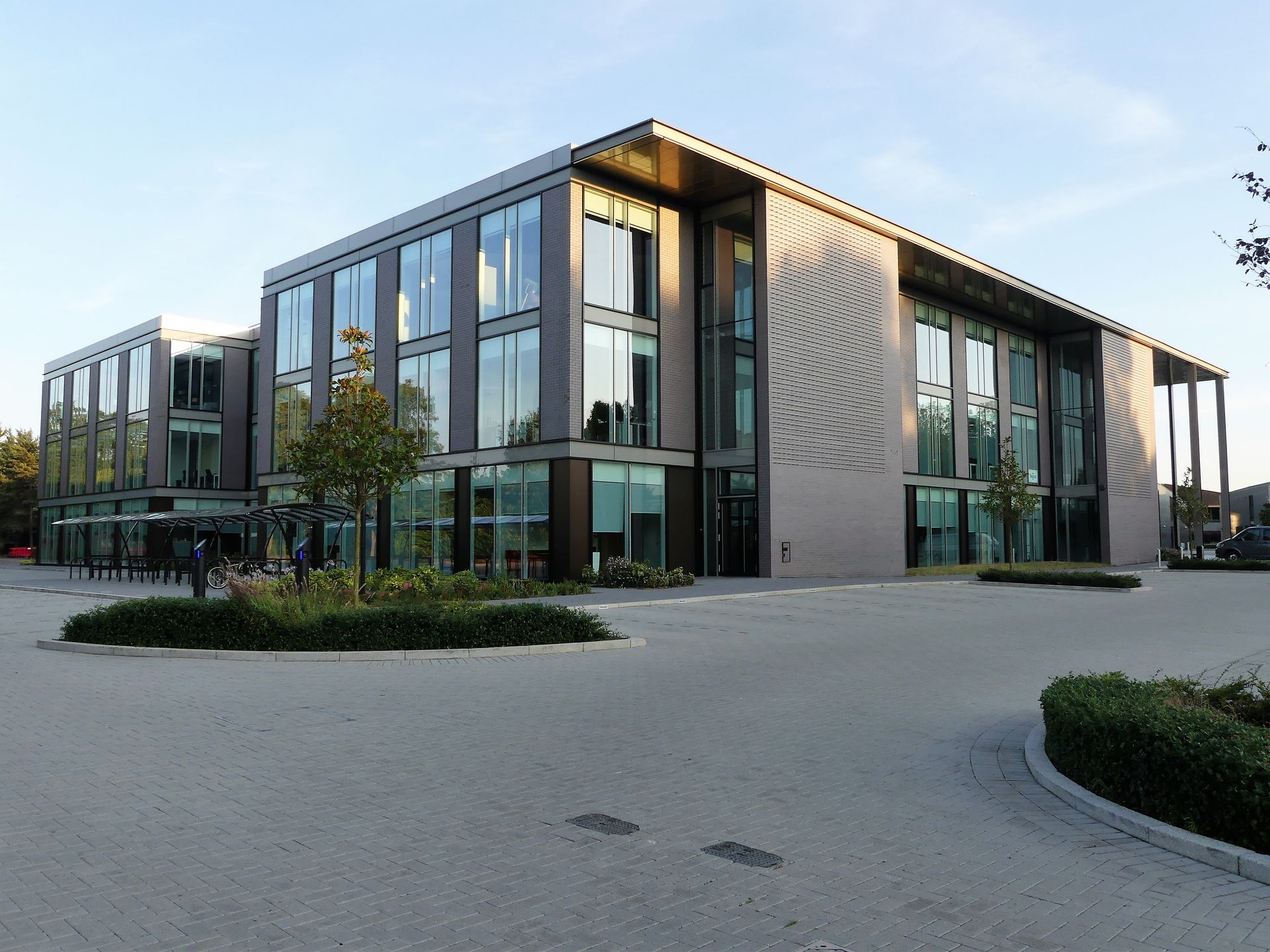 A large building with a lot of windows and a circular driveway in front of it