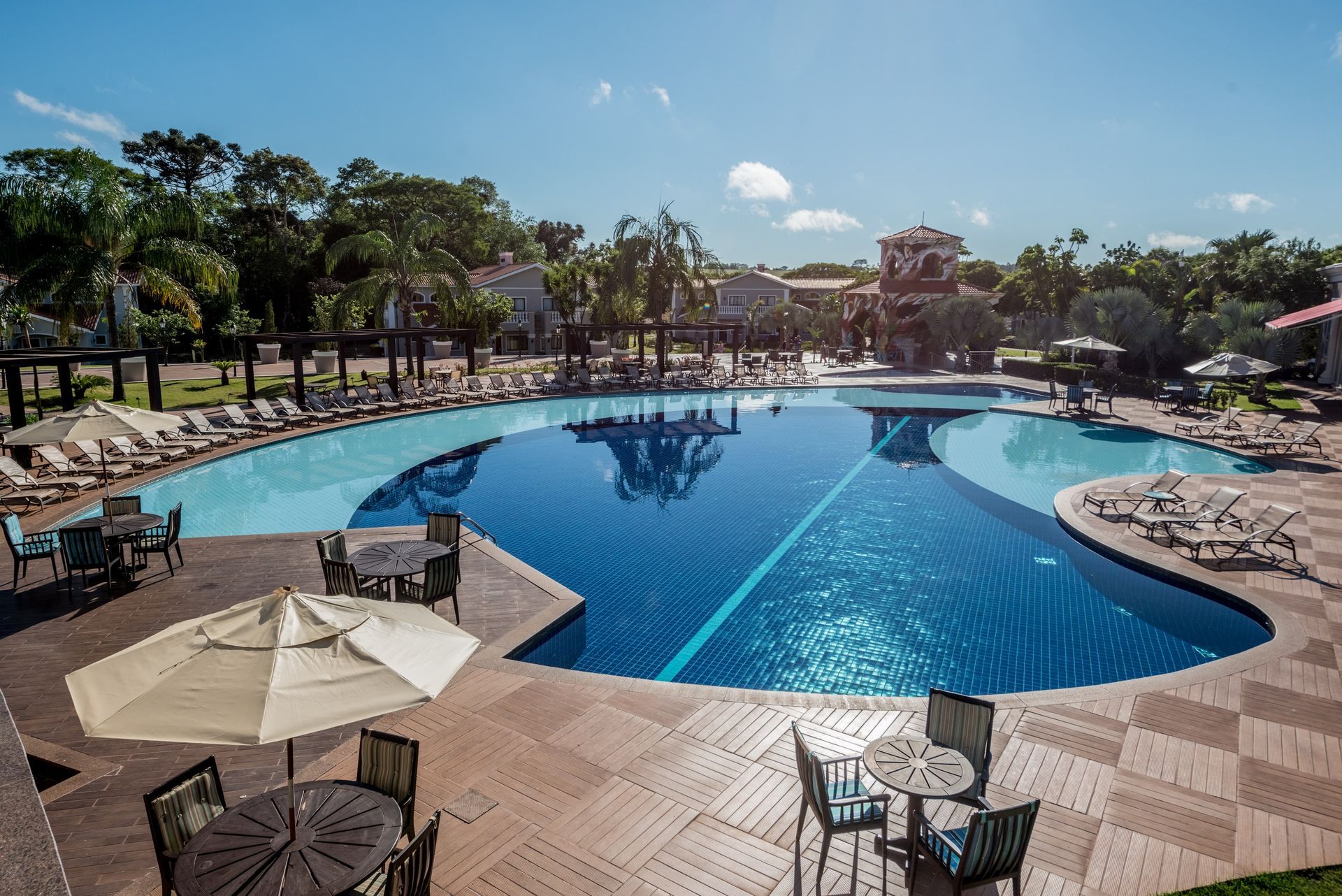 Uma grande piscina com mesas e cadeiras ao redor