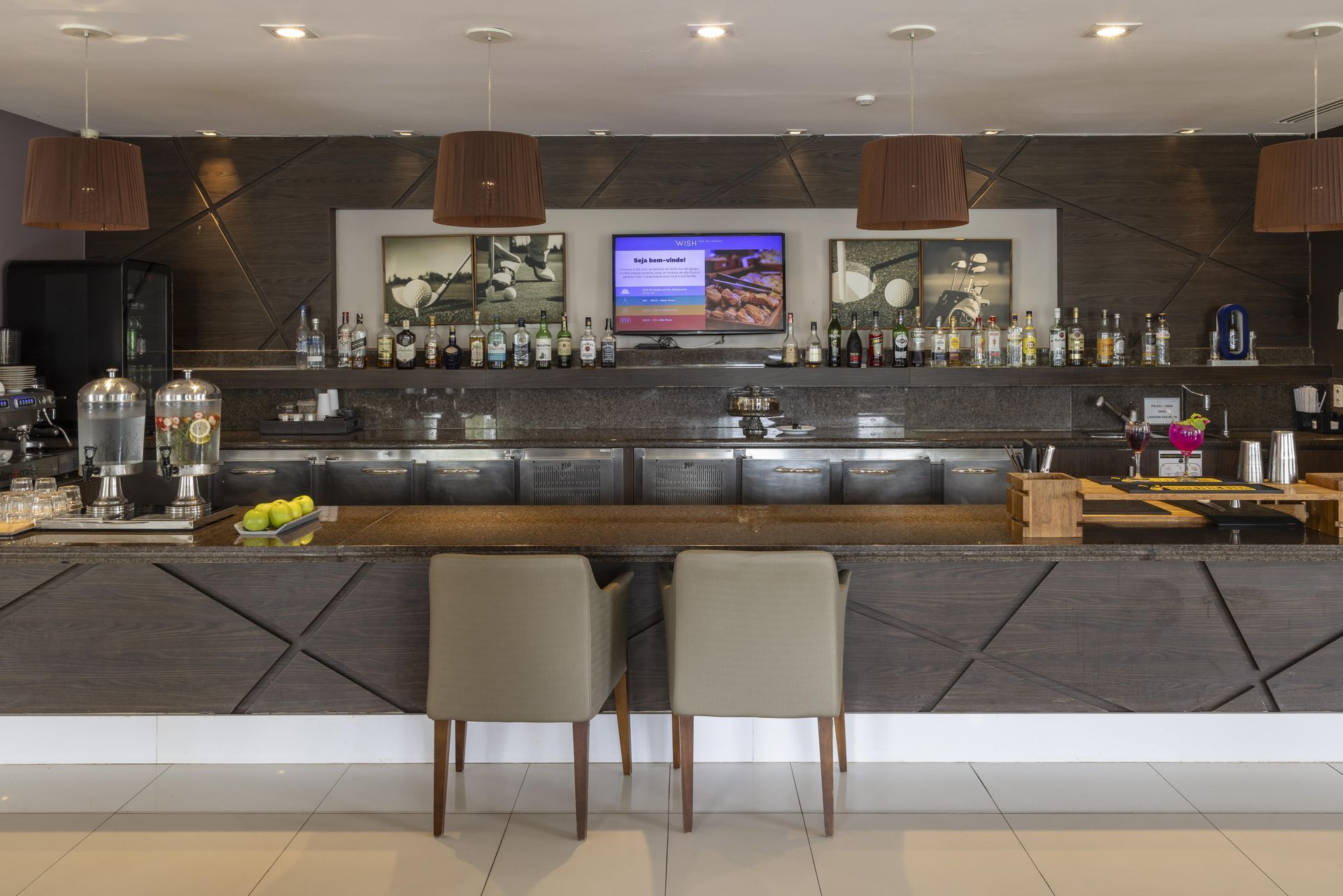 Um bar com duas cadeiras e uma televisão na parede.