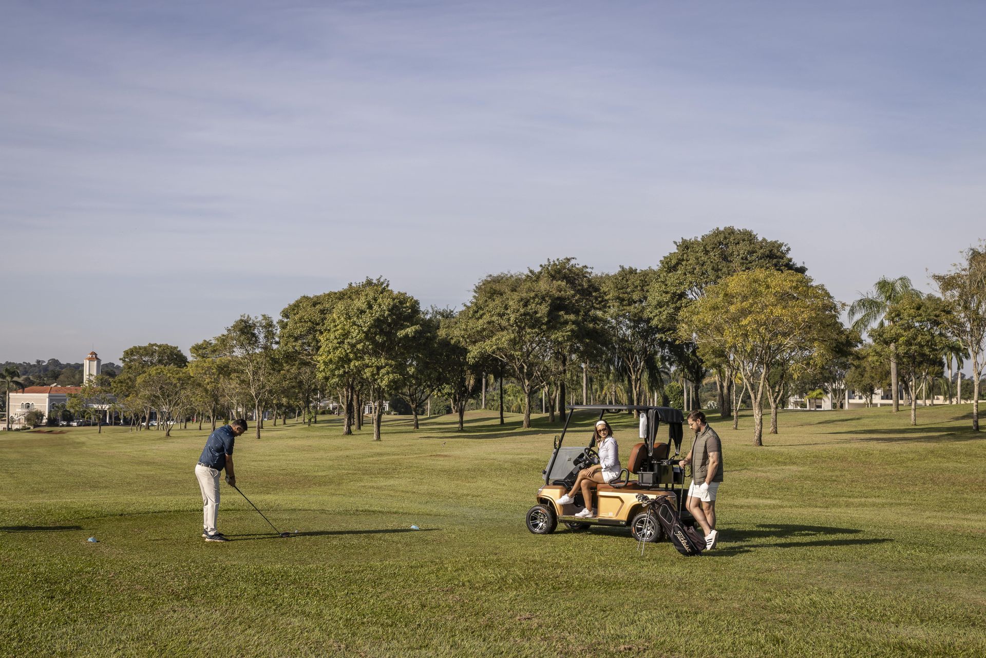 Um grupo de pessoas está jogando golfe em um campo de golfe.