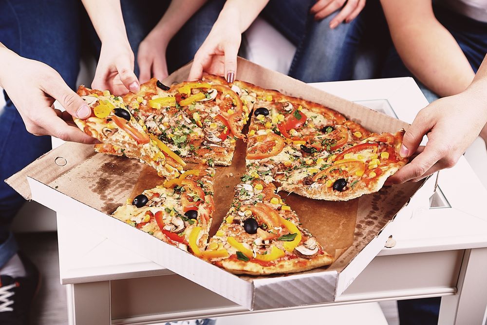A Group of People Are Taking Slices of Pizza Out of a Box — Michelangelos Pizza & Pasta in Kirwan, QLD
