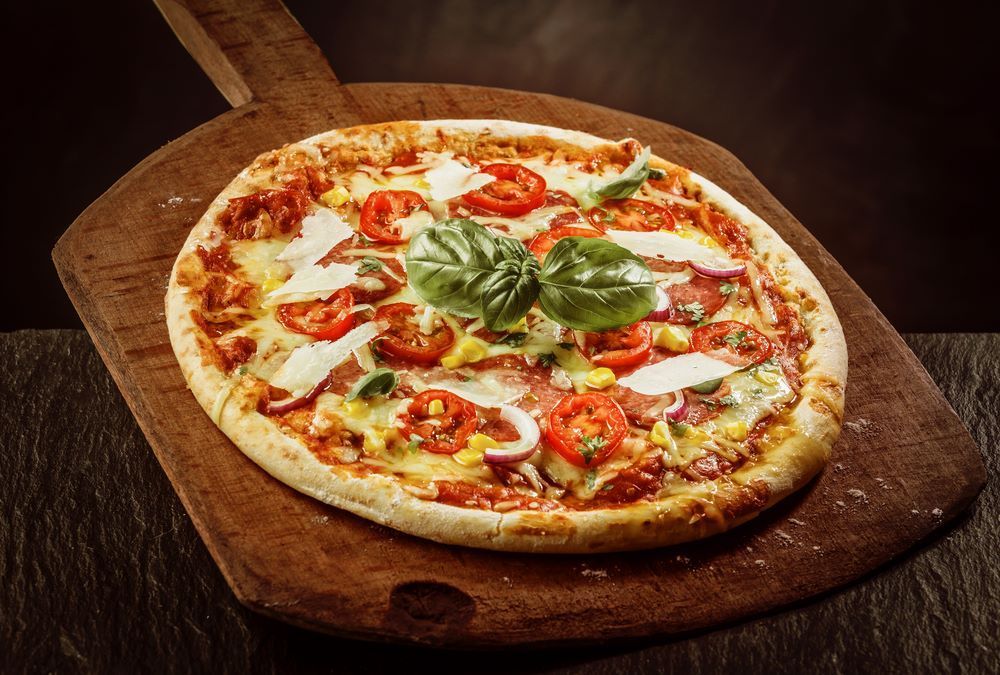 A Pizza is Sitting on a Wooden Cutting Board — Michelangelos Pizza & Pasta in South Townsville, QLD