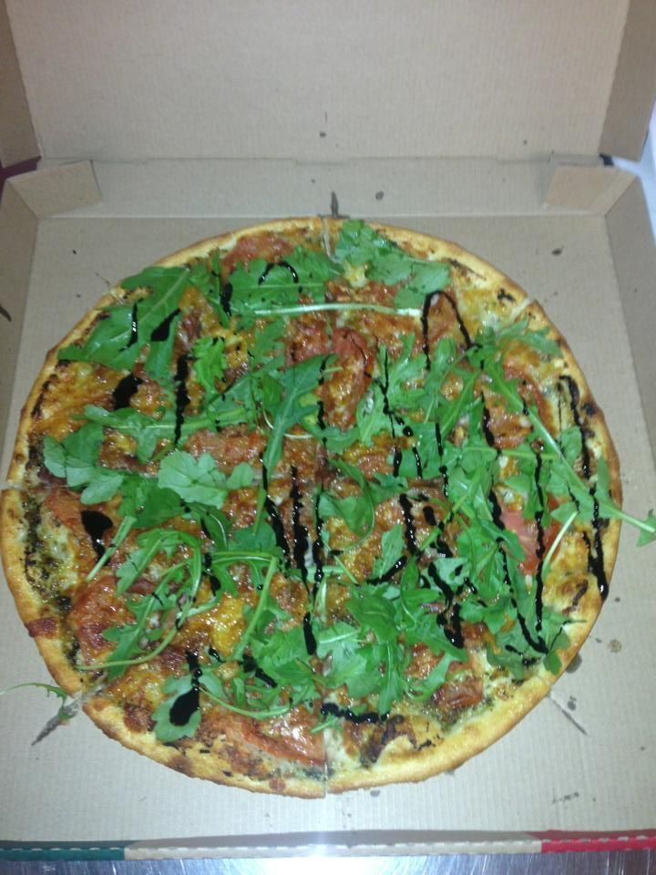 A Pizza in a Cardboard Box With Green Leaves on Top — Michelangelos Pizza & Pasta in Aitkenvale, NSW
